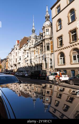 Le case della Spichernstreet si riflettono nel tetto di un'auto, Colonia, Germania. Gruenderzeitbauten in der Spichernstrasse spiegeln sich in einem Autodach, Foto Stock