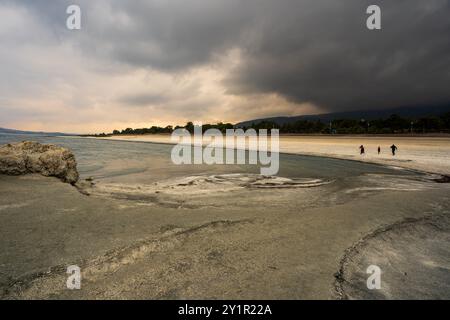 Lago di salda, Turchia - 15 settembre 2021: Tre persone camminano lungo la suggestiva spiaggia marziana del lago di salda, in Turchia, sotto cieli drammatici e tempestosi Foto Stock