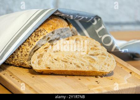 Pane fatto in casa e fette sul tavolo della cucina. Pane di segale con impasto naturale e vista ravvicinata dei semi Foto Stock