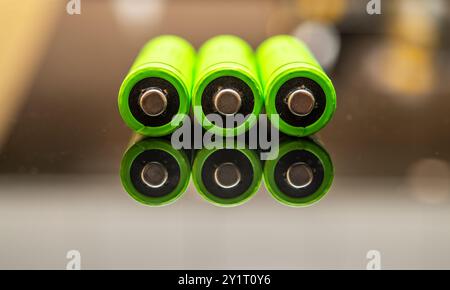 Batterie AAA ricaricabili in verde brillante, che simboleggiano i progressi nel campo delle energie rinnovabili. Celle di alimentazione a risparmio energetico progettate per un consumo eco-consapevole Foto Stock