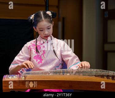 Bella ragazza cinese che indossa un costume tradizionale suonando strumenti musicali a corda all'evento China Focus durante il Festival di Edimburgo, Scozia, Regno Unito Foto Stock