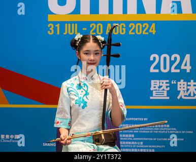 Bella ragazza cinese che indossa un costume tradizionale suonando strumenti musicali a corda all'evento China Focus durante il Festival di Edimburgo, Scozia, Regno Unito Foto Stock