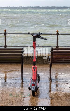 scooter elettrico solitario abbandonato sul lungomare o sul lungomare di cowes sull'isola di wight nel regno unito Foto Stock