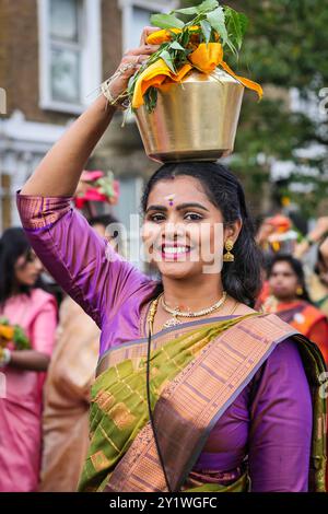 Londra, Regno Unito. 8 settembre 2024. Diverse migliaia di devoti della comunità Tamil prendono parte all'annuale Festival dei carri (Ter) dal tempio di Sivan Kovil per le strade di Lewisham. Le divinità di Ganesha e Lord Shiva sono trasportate in carri decorati. I devoti fanno offerte di latte, incenso bruciato, noci di cocco o frutta. Crediti: Imageplotter/Alamy Live News Foto Stock