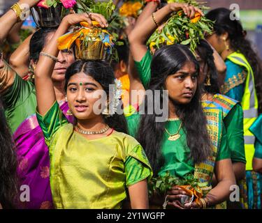 Londra, Regno Unito. 8 settembre 2024. Diverse migliaia di devoti della comunità Tamil prendono parte all'annuale Festival dei carri (Ter) dal tempio di Sivan Kovil per le strade di Lewisham. Le divinità di Ganesha e Lord Shiva sono trasportate in carri decorati. I devoti fanno offerte di latte, incenso bruciato, noci di cocco o frutta. Crediti: Imageplotter/Alamy Live News Foto Stock