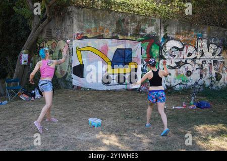 Berlino, Germania. 8 settembre 2024. Il "Görli rimane aperto!" settimana d'azione: lanciare paintbags ai macchinari edili è praticato in modo giocoso. Un'iniziativa dei residenti utilizza la settimana d'azione per protestare contro la costruzione pianificata di una recinzione intorno al Parco Görlitzer. Crediti: Jörg Carstensen/dpa/Alamy Live News Foto Stock