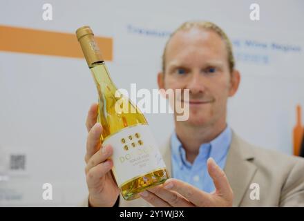 (240908) -- FUZHOU, 8 settembre 2024 (Xinhua) -- Un commerciante di vino ungherese espone una bottiglia di vino prodotta nella zona vinicola di Tokaj in Ungheria durante la 24a Fiera internazionale cinese per gli investimenti e il commercio (CIFIT) a Xiamen, nella provincia del Fujian, nella Cina sudorientale, 8 settembre 2024. Con una superficie di circa 120.000 metri quadrati, il CIFIT di quattro giorni ha aperto qui la domenica e attira visitatori da 119 paesi e regioni, di cui circa il 80% sono paesi partner della Belt and Road Initiative (BRI). Il CIFIT di quest'anno mette in evidenza l'economia digitale, la nuova energia e l'innovazione verde. Si prevede che funga da Foto Stock