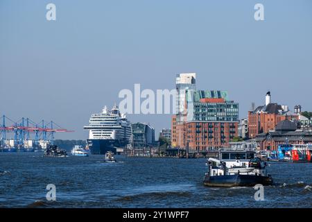 Amburgo, Germania - 09 05 2024: Porto di Amburgo con varie piccole imbarcazioni in primo piano e la nave da crociera Mein Schiff 1 sullo sfondo Foto Stock