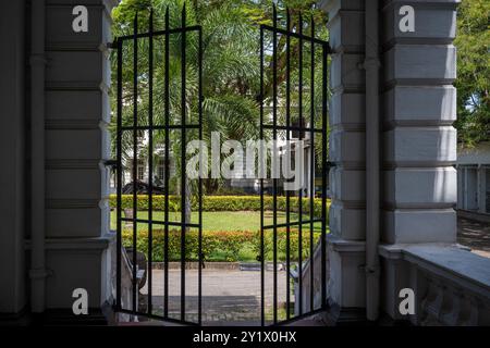 Una foto che guarda attraverso i cancelli che portano ai giardini del Museo Nazionale Colombo in Sri Lanka Foto Stock