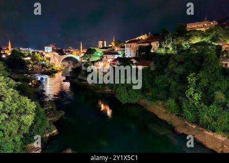 Vista notturna dell'area del Ponte Vecchio della città Vecchia di Mostar. Mostar è una città con una storia molto ricca, situata nel paese montuoso lungo il fiume Neretva. I primi insediamenti umani sul fiume Neretva sono esistiti dalla preistoria. Mostar è da tempo conosciuta per le sue vecchie case turche e il Ponte Vecchio, Stari Most, da cui prende il nome. Il ponte e l'area circostante sono stati inseriti nella lista dei patrimoni dell'umanità dell'UNESCO nel 2005. Il Ponte Vecchio e la città Vecchia di Mostar sono un simbolo di riconciliazione, cooperazione internazionale e della coesistenza di diverse culture, etniche e religiose Foto Stock