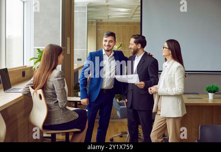 Persone aziendali in ufficio sul posto di lavoro che discutono di un affare o di un progetto di lavoro di successo. Foto Stock