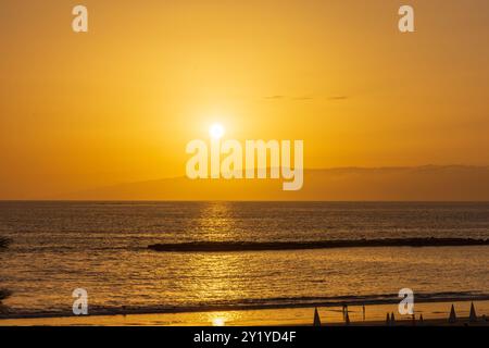 Orangener Sonneuntergang hinter la Palma im Atlantik von der Westküste Teneriffas in Costa Adeje betrachtet. Foto Stock