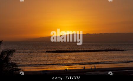 Orangener Sonneuntergang hinter la Palma im Atlantik von der Westküste Teneriffas in Costa Adeje betrachtet. Foto Stock