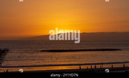 Orangener Sonneuntergang hinter la Palma im Atlantik von der Westküste Teneriffas in Costa Adeje betrachtet. Foto Stock