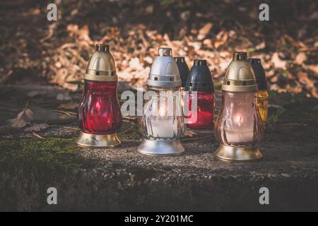 candele accese sulla tomba decorata nel cimitero Foto Stock
