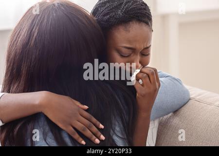 Donna che abbraccia il suo pianto ragazza, supportando la sua dopo aver ricevuto cattive notizie Foto Stock