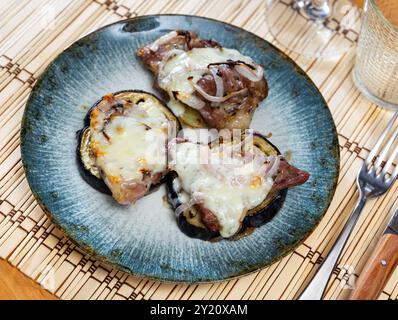 Carne al forno su melanzane e patate sotto formaggio Foto Stock