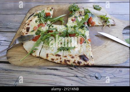 Flambee originale alla tarte con pancetta e rucola servito su una tavola di legno in un ristorante giardino, Baden-Wuerttemberg, Germania, Europa Foto Stock