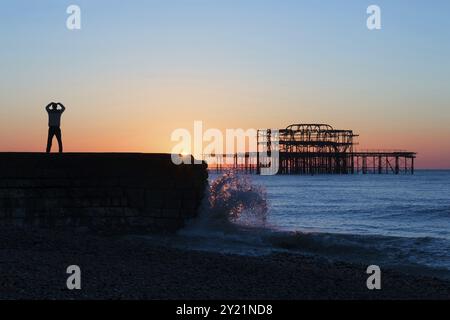 Persona che pratica Tai chi all'alba vicino al West Pier, Brighton Foto Stock