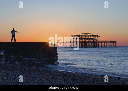 Persona che pratica Tai chi all'alba vicino al West Pier, Brighton Foto Stock