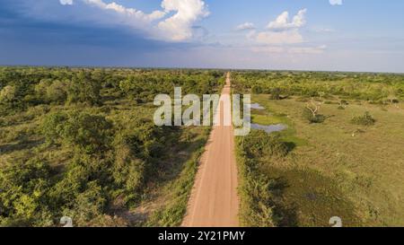 Vista aerea con nuvole e cielo blu all'orizzonte della strada sterrata Transpantaneira che attraversa direttamente le zone umide di Pantanal Nord, Mato grosso, Brasile, S. Foto Stock