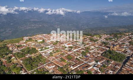 Vista aerea della città storica di Barichara, in Colombia, con un crinale di montagna ricoperto di nuvole bianche sullo sfondo Foto Stock