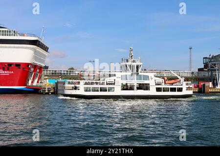 Il traghetto di Suomenlinna passa per la Viking Line Cenerentola attraccata al porto di Helsinki Katajanokka, Finlandia, agosto 2024 Foto Stock