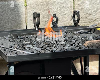 Forgia da fabbro, combustione di carbone con utensili da fabbro, artigianato tradizionale in un'officina di forge, concetto di officina di forgia Foto Stock