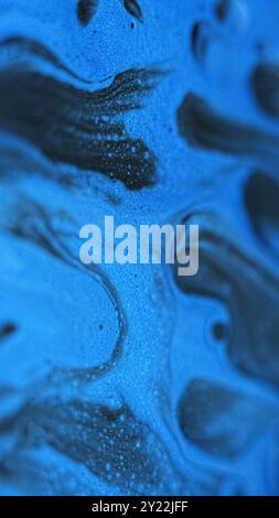 Vernice lucida. Goccia di bolle. Inchiostro brillante. Sfocatura di colore blu bianco nero movimento fluido fluido brillante miscela gel glitter sfondo artistico astratto. Foto Stock