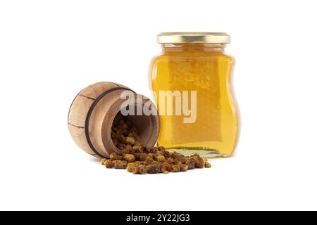 Pane naturale d'ape traboccante da una botte di legno, accanto a un vaso di vetro traboccante di miele dorato, il tutto su sfondo bianco Foto Stock