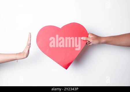 Una foto di un cuore negato da qualcuno, isolato su sfondo bianco. Concetto d'amore non corrisposto. Foto Stock