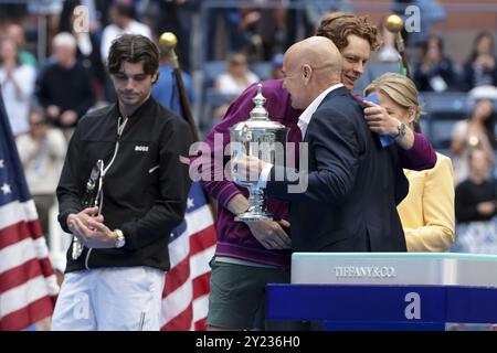 Il vincitore Jannik Sinner d'Italia riceve il trofeo da Andre Agassi, mentre il finalista Taylor Fritz degli Stati Uniti (L) guarda durante la cerimonia del trofeo della finale maschile del#39 il giorno 14 del torneo di tennis del grande Slam degli US Open 2024 l'8 settembre 2024 presso l'USTA Billie Jean King National Tennis Center di Flushing Meadows, Queens, New York, Stati Uniti Foto Stock