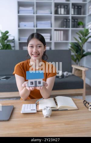 woman elabora un piano di risparmio finanziario incentrato sulla garanzia di un prestito residenziale, gestendo con attenzione il proprio budget per raggiungere la proprietà familiare e la fin a lungo termine Foto Stock