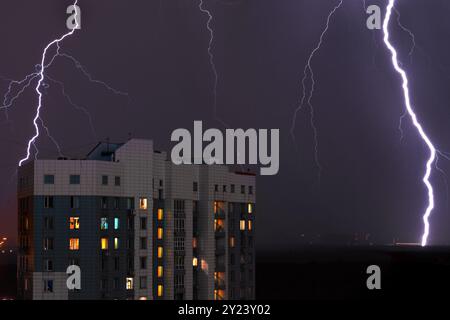 Tempesta con fulmini fulmini e tempesta sulla città con luce viola di notte, con il primo piano delle finestre Foto Stock