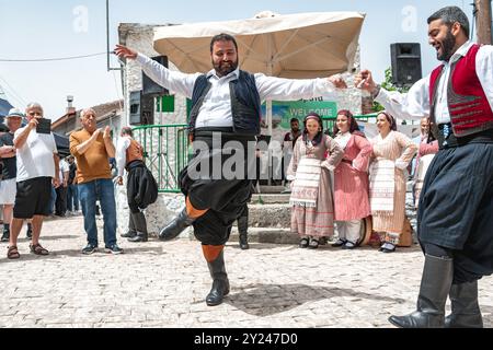 Dora (Dhora), Limassol District, Cipro - 28 maggio 2023: Uomo in abiti tradizionali che danzano al festival del villaggio di Dora circondato da musicisti e spect Foto Stock