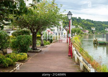 Un sentiero sul lungomare lungo la Senna nel pittoresco villaggio di la Bouille, Normandia, Francia Foto Stock