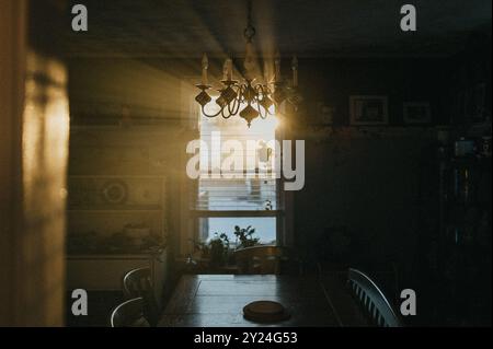 raggi di sole attraverso la finestra della sala da pranzo e il lampadario Foto Stock