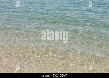 Acqua di mare limpida e poco profonda con lievi increspature sul fondo sabbioso Foto Stock