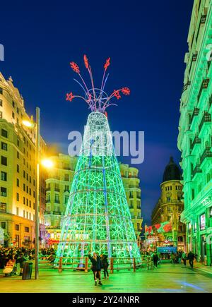 Atmosfera natalizia con persone che passeggiano intorno a un grande albero di Natale illuminato in Montera Street. Madrid, Spagna. Foto Stock