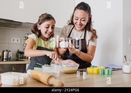 La madre single si diverte mentre cuoci i biscotti con la figlia Foto Stock