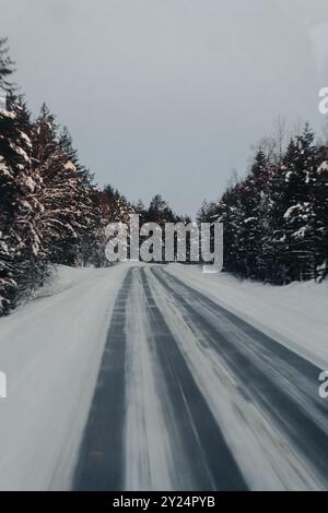 Strada innevata attraverso la foresta lappone a Ranua, Lapponia Foto Stock