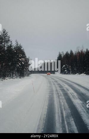 Strada che attraversa la natura selvaggia della Lapponia in inverno a Ranua, Lapponia Foto Stock