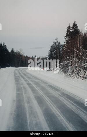 Strada vuota attraverso la foresta lappone a Ranua, Lapponia Foto Stock