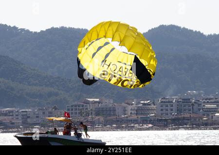 Mugla, Marmaris, Turchia - 03.07.2024 parasailing giallo trainati da un motoscafo. Idea di sport estremi. Attività di parasailing a Marmaris. Foto Stock