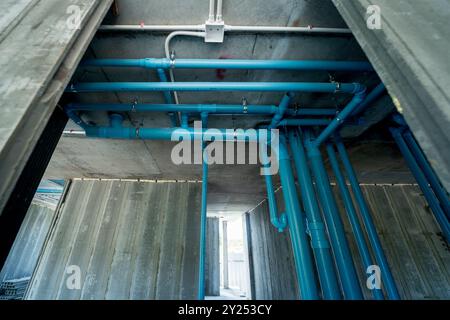 Un grande edificio attualmente in costruzione che ha molti tubi blu Foto Stock