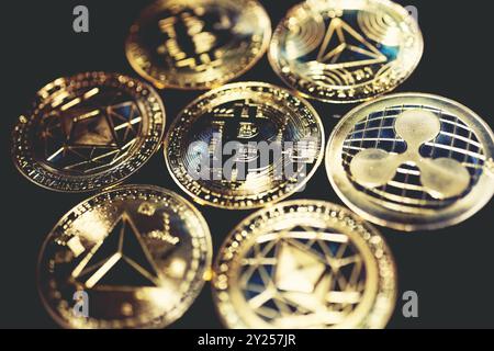 Bitcoin, Ethereum, XRP e TRX monete d'oro su sfondo nero. Concetto finanziario e di investimento. Foto Stock