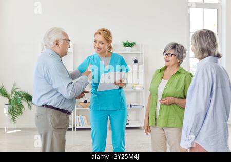 Medico o infermiere che conduce un incontro per il gruppo di pazienti anziani presso la Casa di cura Foto Stock