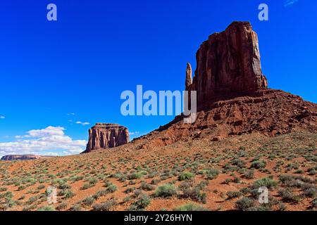 West Mitten e Merrick Buttes sotto il cielo azzurro della Monument Valley Foto Stock