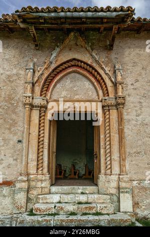 Il portale tardo gotico, con colonne ritorte e un alto timpano e i resti di un affresco all'ingresso della chiesa della Madonna del Casale. Foto Stock