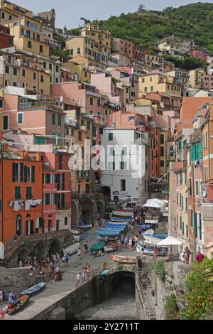 La colorata cittadina costiera di Riomaggiore, situata tra le cinque Terre più famose d'Italia, viene mostrata durante il giorno in una vista verticale. Foto Stock